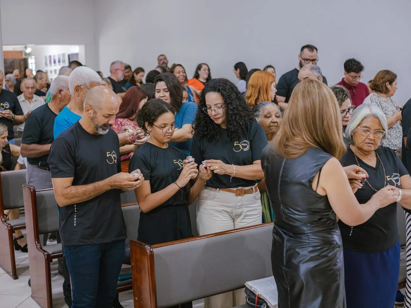 Irmãos se cumprimentando nos bancos antes do culto