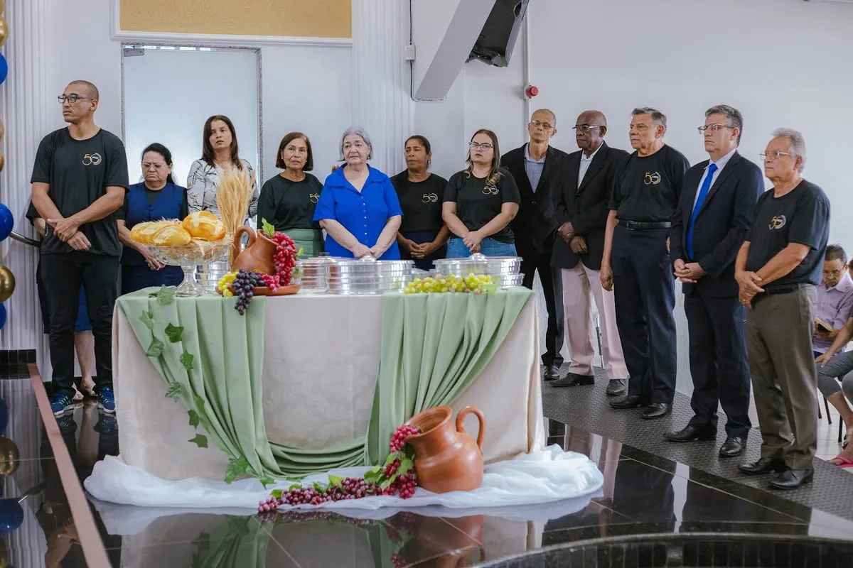 Mesa da Ceia do Senhor preparada, com a equipe em volta