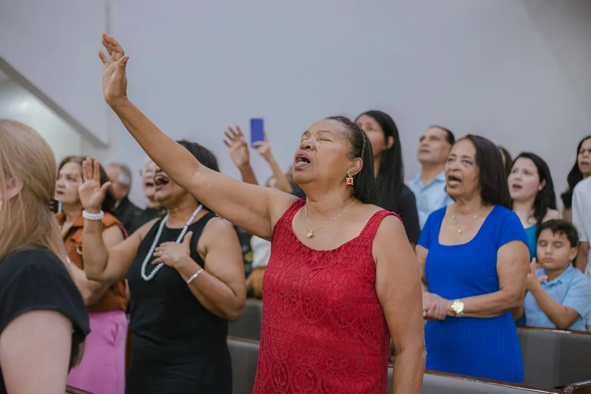 Irmãs cantando de mãos levantadas